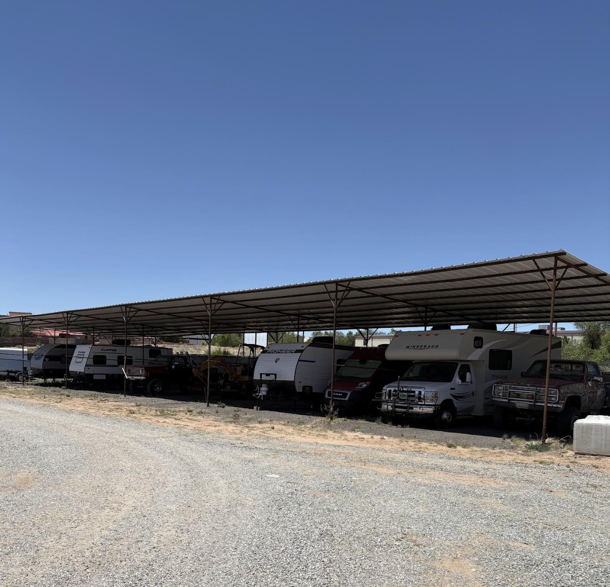 Motorhomes and trailers lined up under cover, out of the weather.